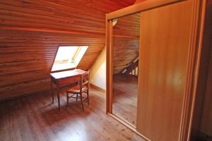 an attic room with a desk and a window at Rosalie in Masléon