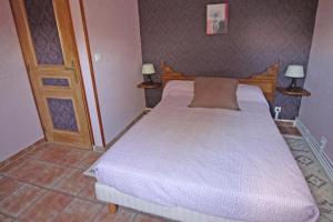 a bedroom with a bed and two lamps on the wall at Rosalie in Masléon
