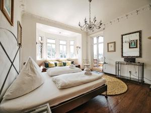 two beds in a room with white walls and a chandelier at Rottenhöfer Retreat Villa in Berchtesgaden