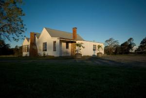 una vecchia casa bianca con un camino in cortile di Buttons Cottage for a northwest Tassie escape a Nietta