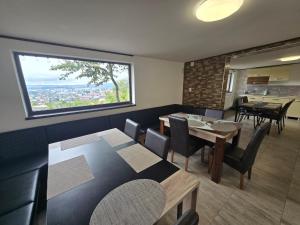 a dining room with tables and chairs and a large window at Bella Vista Bungalow in Turda