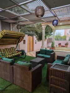 a patio with chairs and tables and an umbrella at Luxury Apartment in Aqaba in Aqaba