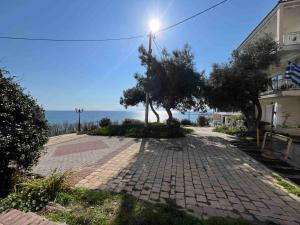 a brick walkway with trees in front of a building at Serene Vintage in Nea Moudania +11 photos