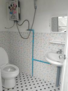 a bathroom with a toilet and a sink at Mon Mon Homestay in Mon Jam