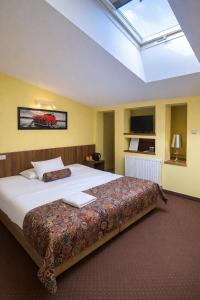 a bedroom with a large bed and a skylight at Hotel Ajax in Janki +35 photos