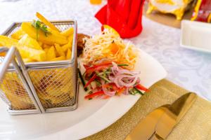 a plate with a salad and chips on a table at Arise Sunshine Hotel in Narok +29 photos