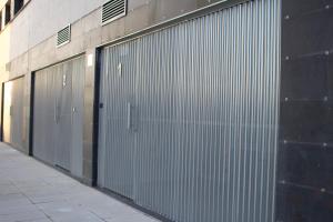 a row of metal garage doors on a building at Apartamentos Lumael in Mérida