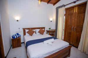 a bedroom with a large bed with towels on it at Palms shede Villa in Habaraduwa Central