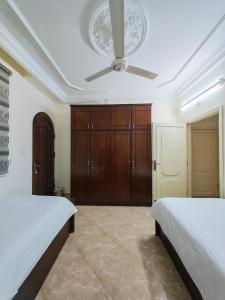 a bedroom with two beds and a ceiling fan at Luxury Apartment in Aqaba in Aqaba