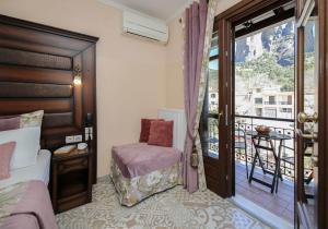 a hotel room with a bed and a balcony at Alsos House in Kalabaka
