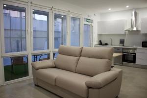 a living room with a couch and a kitchen at Apartamentos Lumael in Mérida