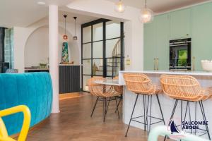a kitchen with wicker stools and a counter top at Chic Devon Designer Oasis with hot tub in Malborough
