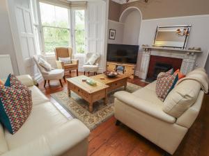 a living room with white furniture and a fireplace at 1 Park Road in Windermere