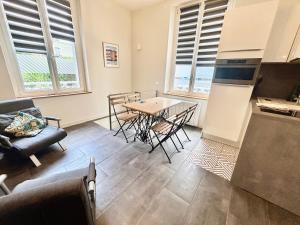 a kitchen and living room with a table and chairs at L'Escale à Villerville in Villerville