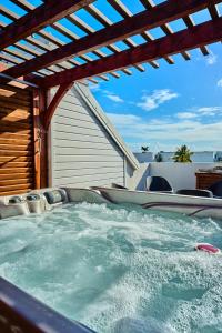 an outdoor hot tub with a wooden pergola at Only4view - Rooftop & spa Sainte-Anne in Sainte-Anne