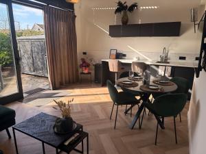 a kitchen and living room with a table and chairs at Cozy & Modern Tiny House in Velserbroek 