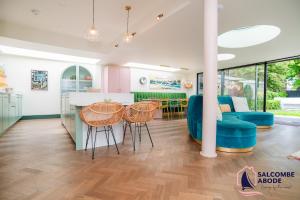 a kitchen and living room with a table and chairs at Chic Devon Designer Oasis with hot tub in Malborough +43 photos