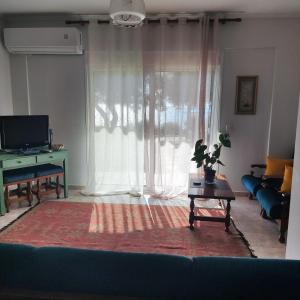 a living room with a large window and a couch at Serene Vintage in Nea Moudania