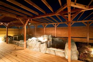 町田市にあるラクシオ・インの岩と木製の天井が特徴の広い客室です。
