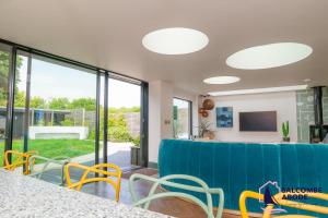 a dining room with a blue couch and chairs at Chic Devon Designer Oasis with hot tub in Malborough