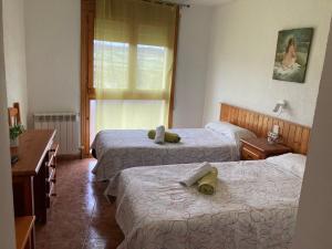 a hotel room with two beds and a window at Montrebei Casa González Apartamentos in Tolva