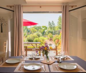 a table with glasses and a vase of flowers on it at Le jardin des 4 saisons in Le Mans