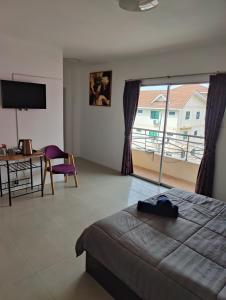 a bedroom with a bed and a view of a balcony at Nana's Bar & Hotel in Nong Prue