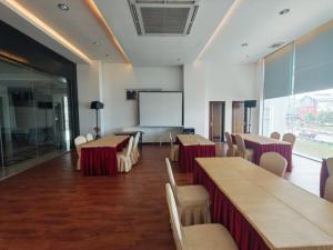 a conference room with tables and chairs and a whiteboard at Kingston Hotel 18 - Kuala Lumpur Sri Damansara in Kuala Lumpur
