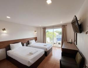 a hotel room with two beds and a television at Hi2 Cha-Am in Cha Am