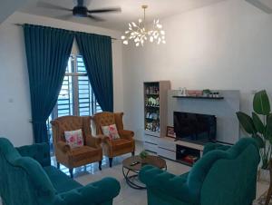 a living room with blue chairs and a fireplace at Seri Jerantut Homestay in Jerantut