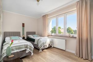 a bedroom with two beds and a window at Marina Apartament Old Town View in Kamień Pomorski