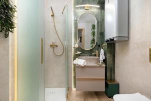 a bathroom with a shower and a sink and a mirror at Marina Apartament Old Town View in Kamień Pomorski