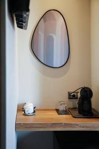 a mirror on a wall above a wooden table at Corso Italia Rooms in Milan