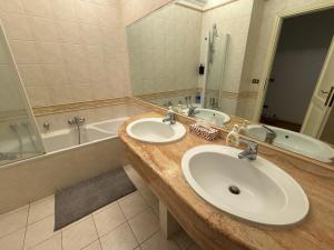 a bathroom with two sinks and a tub at Gt holiday in Rome