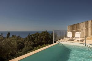 a swimming pool with a view of the ocean at Magganos Sunset Villas in Fiskardo