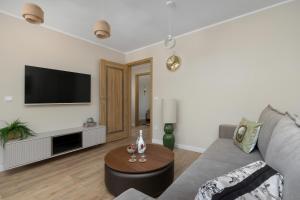 a living room with a couch and a table at Marina Apartament Old Town View in Kamień Pomorski