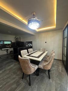 a dining room with a table and chairs and a chandelier at AH Homes Kulai in Kulai +10 photos