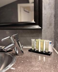 a row of four cups sitting on a bathroom sink at Hotel B Lodge in Saint-Tropez +86 photos