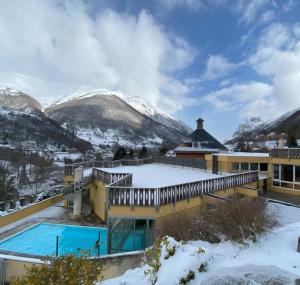 a resort with a swimming pool in the snow at Douce Altitudes Cauterets in Cauterets