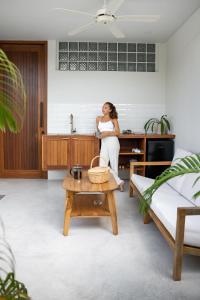 a woman standing in a kitchen with a table at Adults Only Luxury Villa-Gym&Recovery Access in Kuta Lombok
