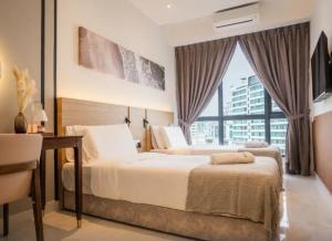a bedroom with a bed and a desk and a window at Inap II, Suterabay By Ayuhouz in Kota Kinabalu +28 photos
