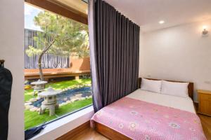 a bedroom with a bed and a large window at White Horse Homestay in Hue