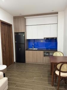 a kitchen with a table and a black refrigerator at Lighthouse Apartment in Ða Gia