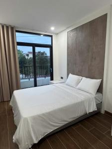 a bedroom with a large white bed with a large window at Lighthouse Apartment in Ða Gia