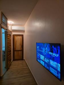 ein Flachbildfernseher an einer Wand im Flur in der Unterkunft The CRADLE in Daressalam
