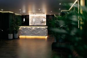 a dark room with plants and a lobby at Relax Resort in Reshetilovskiy Kut