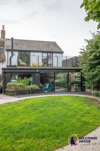 an extension of a house with a lawn at Chic Devon Designer Oasis with hot tub in Malborough
