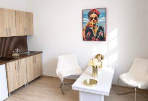 a kitchen with a table and two chairs and a painting at Old Town Studio - Stay Olomouc CZ in Olomouc