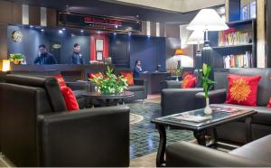 a waiting room with couches and tables in a library at HM Suites & Studios in Bangalore