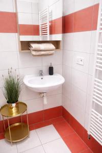 a bathroom with a white sink and red and white tiles at Old Town Studio - Stay Olomouc CZ in Olomouc